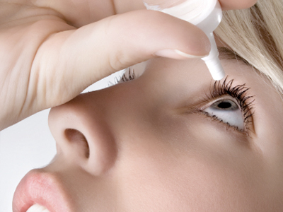 woman putting eye drops in